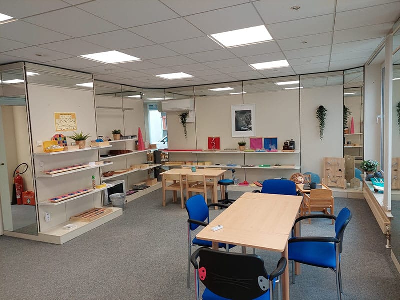 Großer Therapieraum mit Tischen und Regalen voller Montessori-Material